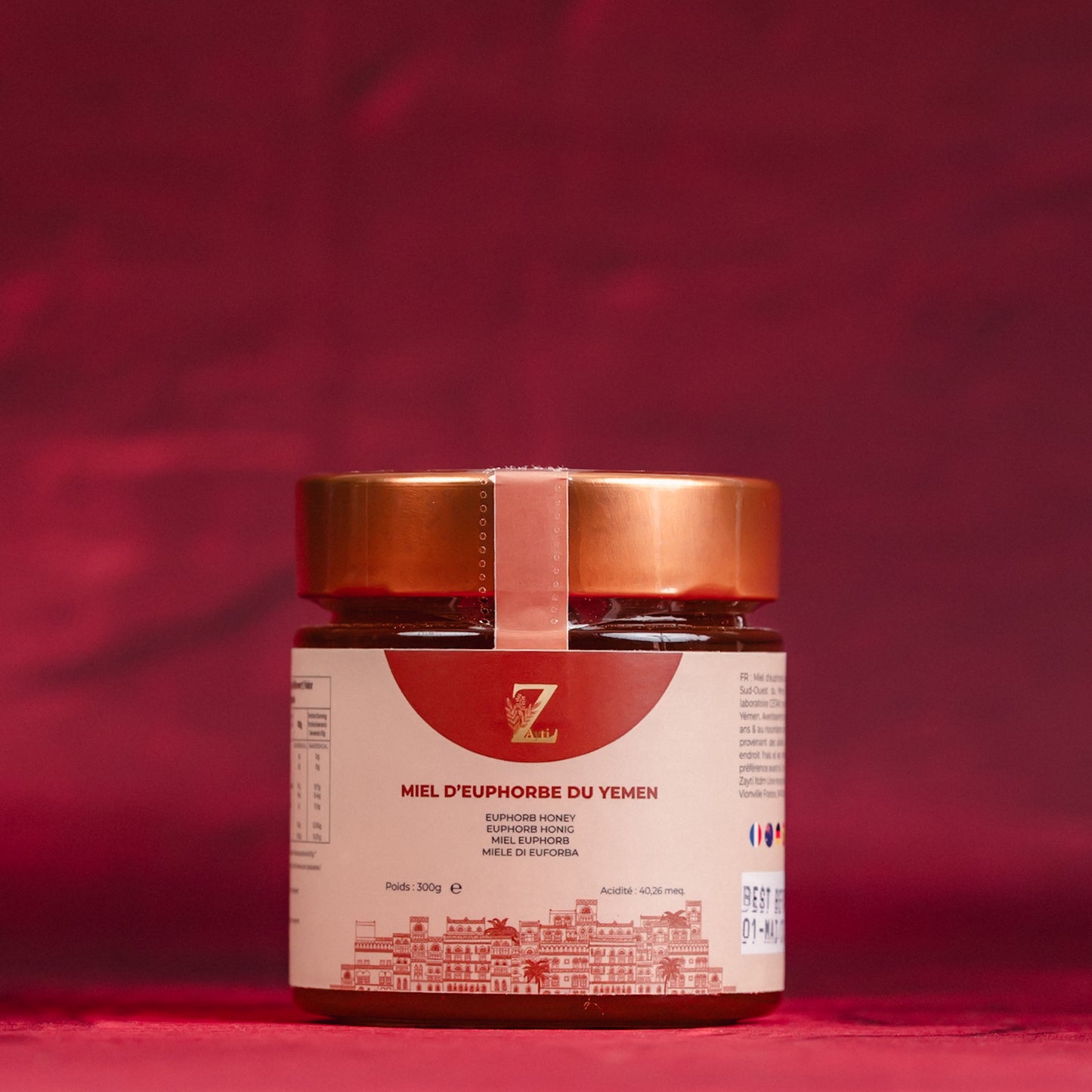 Jar of Yemen euphoria honey with a red label on a red background