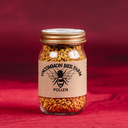Jar of pollen from Uncommon Bee Farm on a red background